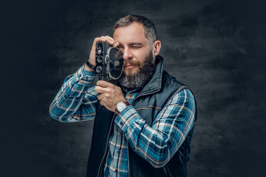 bearded-middle-age-male-holds-vintage-8-mm-video-camera-.jpg